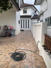 Outdoor area with tiled flooring and garden hose