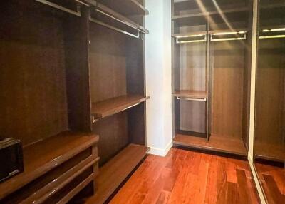 Spacious walk-in closet with wooden shelves and racks