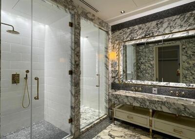 Luxurious bathroom with marble decor and glass shower stalls