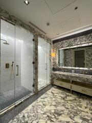 Luxurious bathroom with marble decor and glass shower stalls