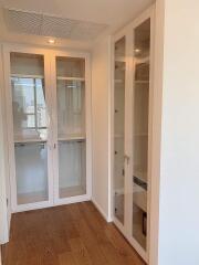 Hallway with glass cabinets and wooden floor