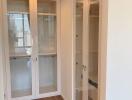 Hallway with glass cabinets and wooden floor