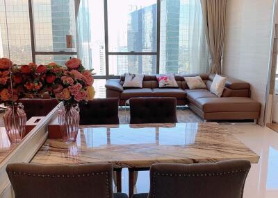 Modern living room with large windows and a dining area