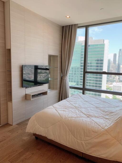 Modern bedroom with a large window and city view