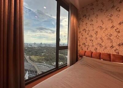 Bedroom with large window and city view