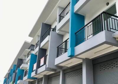 Modern multi-story building with blue and gray facade and balconies