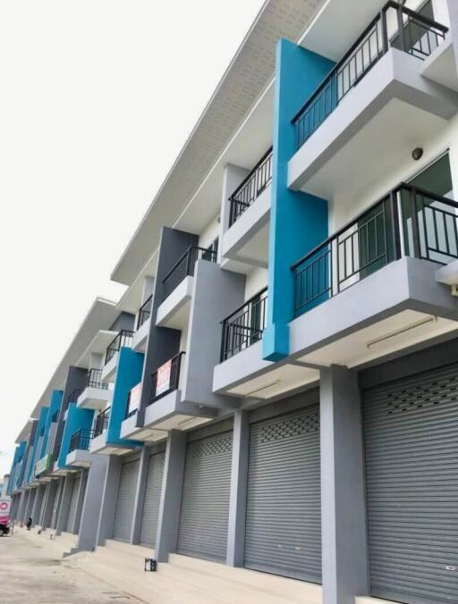 Modern multi-story building with blue and gray facade and balconies