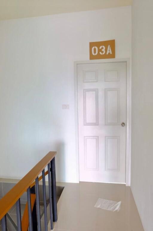 Staircase leading to a white door with room number 03A