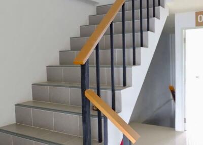 Indoor staircase with black metal railings and wooden handrails