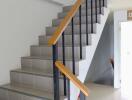 Indoor staircase with black metal railings and wooden handrails