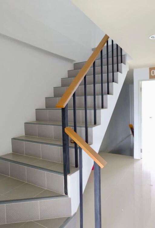 Indoor staircase with black metal railings and wooden handrails