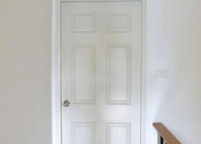 A white door with six panels in a hallway