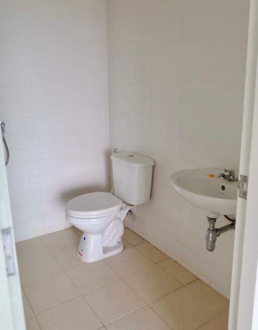 Simple white bathroom with toilet and wall-mounted sink