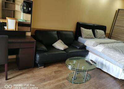 Bedroom with bed, sofa, desk, and glass coffee table