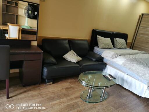 Bedroom with bed, sofa, desk, and glass coffee table