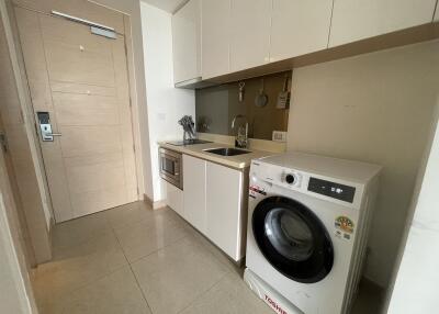 Compact modern kitchen with integrated appliances and washing machine