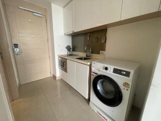 Compact modern kitchen with integrated appliances and washing machine