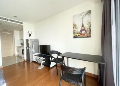 Modern living area with wooden floor, open kitchen, and natural light