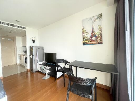 Modern living area with wooden floor, open kitchen, and natural light