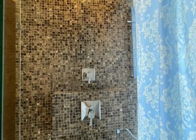 Shower area with tiled walls and patterned shower curtain