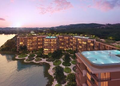 Aerial view of a modern apartment complex with rooftop pools at sunset.