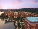 Aerial view of a modern apartment complex with rooftop pools at sunset.