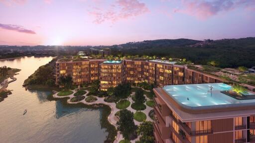 Aerial view of a modern apartment complex with rooftop pools at sunset.