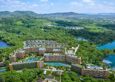 Aerial view of a large residential complex surrounded by greenery and water bodies