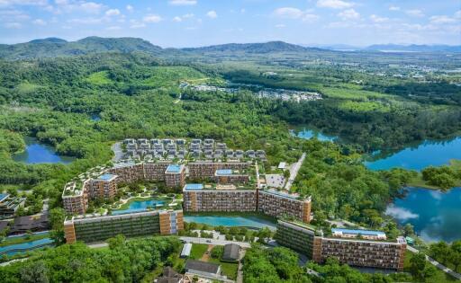 Aerial view of a large residential complex surrounded by greenery and water bodies