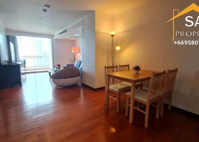 Living area with wooden flooring, dining table, and lounge space