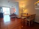 Living area with wooden flooring, dining table, and lounge space