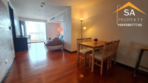 Living area with wooden flooring, dining table, and lounge space