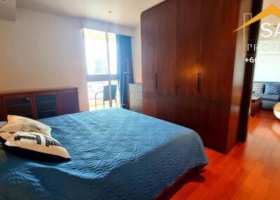 Spacious bedroom with wooden floors and large wardrobe