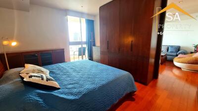 Spacious bedroom with wooden floors and large wardrobe