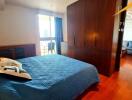 Spacious bedroom with wooden floors and large wardrobe