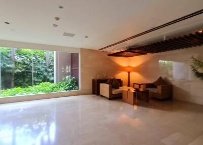 Spacious living area with large windows and indoor plants