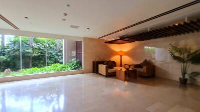 Spacious living area with large windows and indoor plants