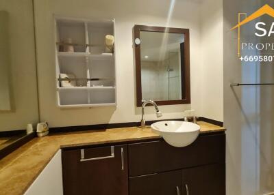 Modern bathroom with sink, mirror, and corner shelf