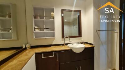 Modern bathroom with sink, mirror, and corner shelf