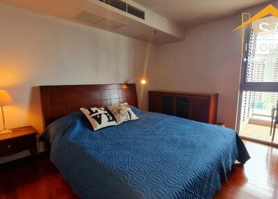 Well-lit bedroom with a large bed and balcony access