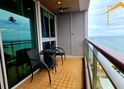 A balcony with outdoor seating and an ocean view