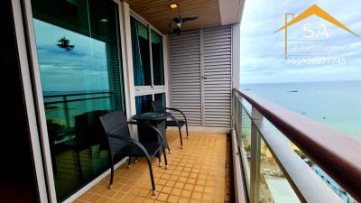 A balcony with outdoor seating and an ocean view