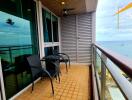 A balcony with outdoor seating and an ocean view