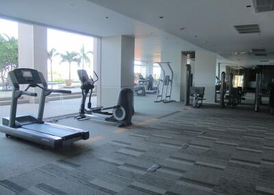 Spacious gym with modern exercise equipment and window view