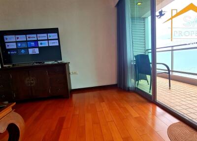 Living room with wooden flooring, TV, balcony access and partial sea view