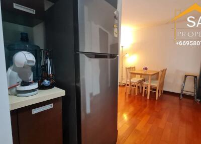 Kitchen and dining area with wooden flooring and refrigerator