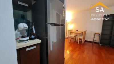 Kitchen and dining area with wooden flooring and refrigerator