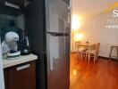 Kitchen and dining area with wooden flooring and refrigerator