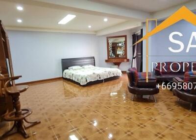 Spacious bedroom with bed, seating area, and tiled floor