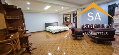 Spacious bedroom with bed, seating area, and tiled floor